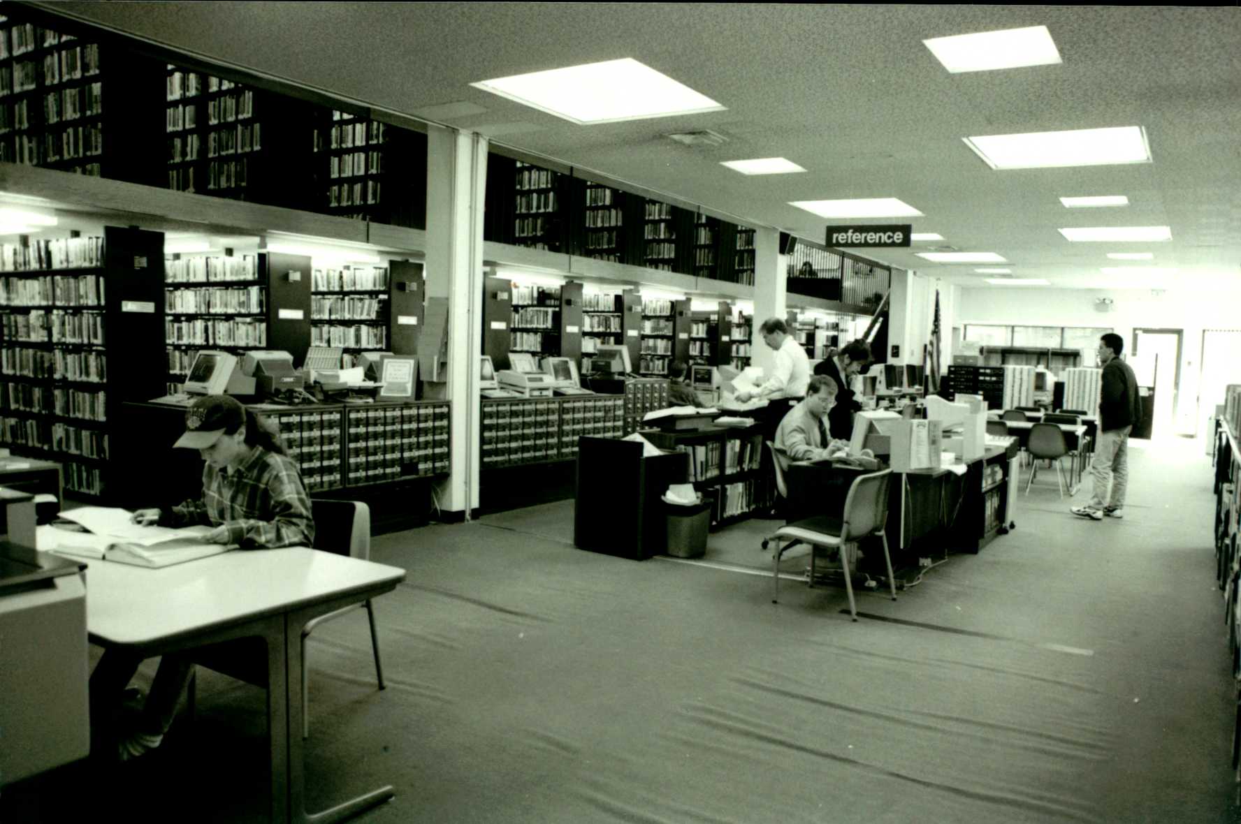 Black and white photo of Lindenhurst Memorial Library reference desk. 