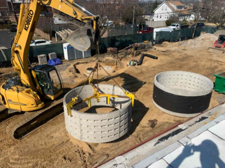 Crane placing large cement drain pipes. 