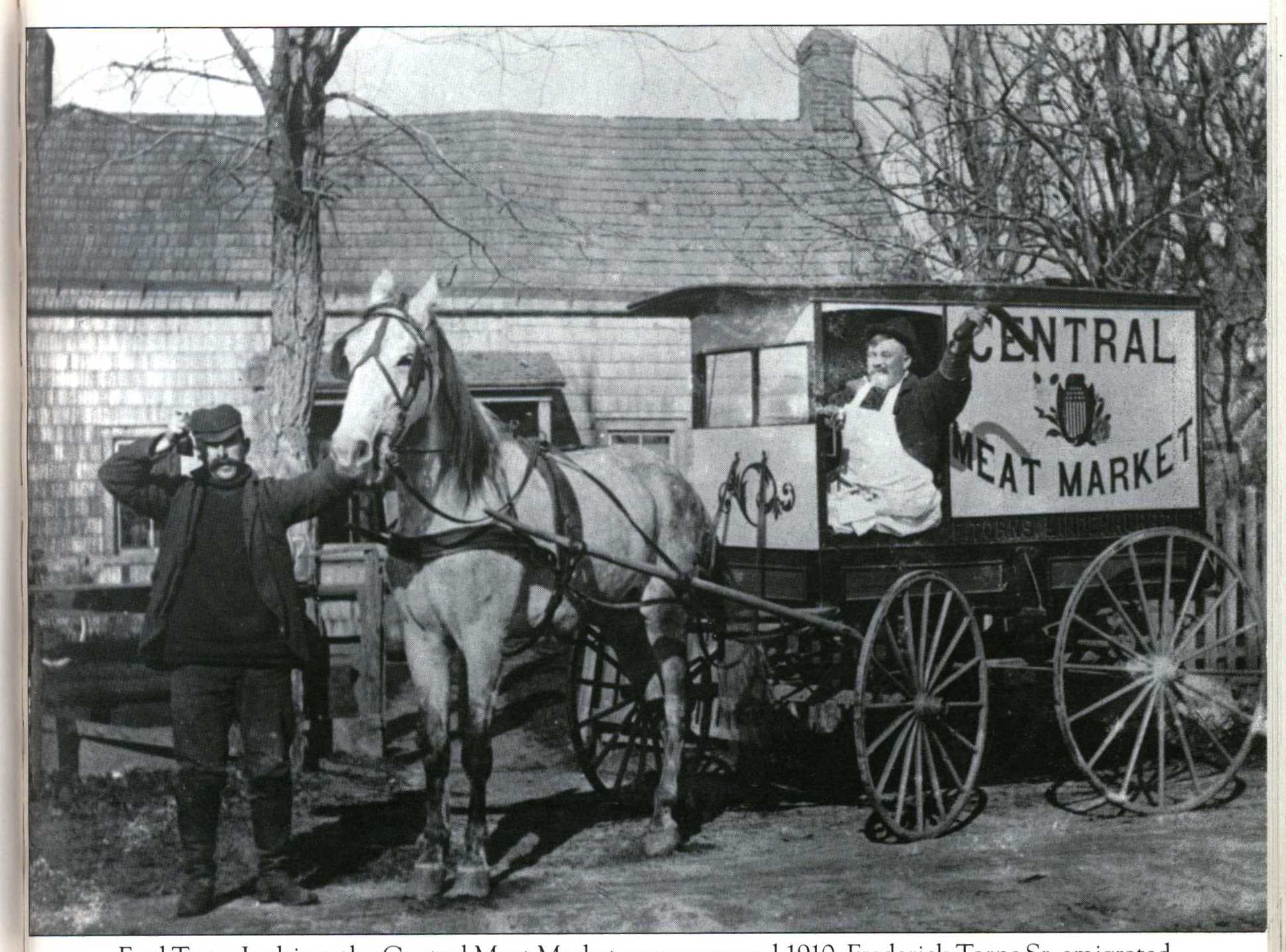 Black and white photo of two men with horse and carriage. 
