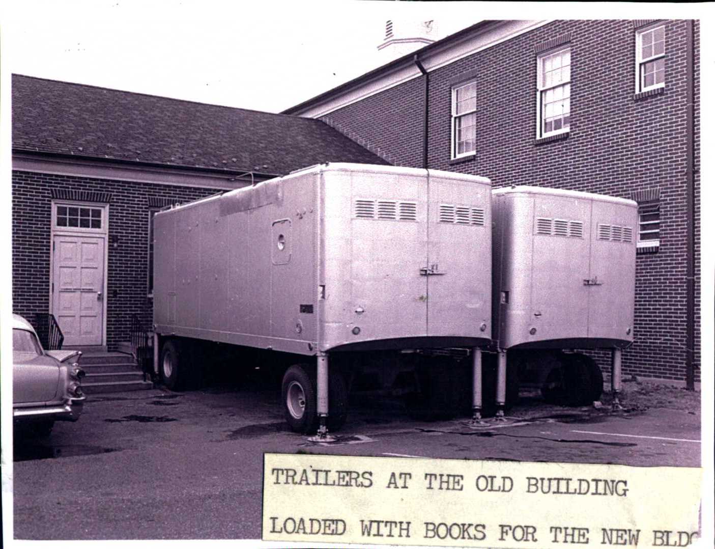 Black and white photo of semi-trailers filled with books in LML loading bay. 
