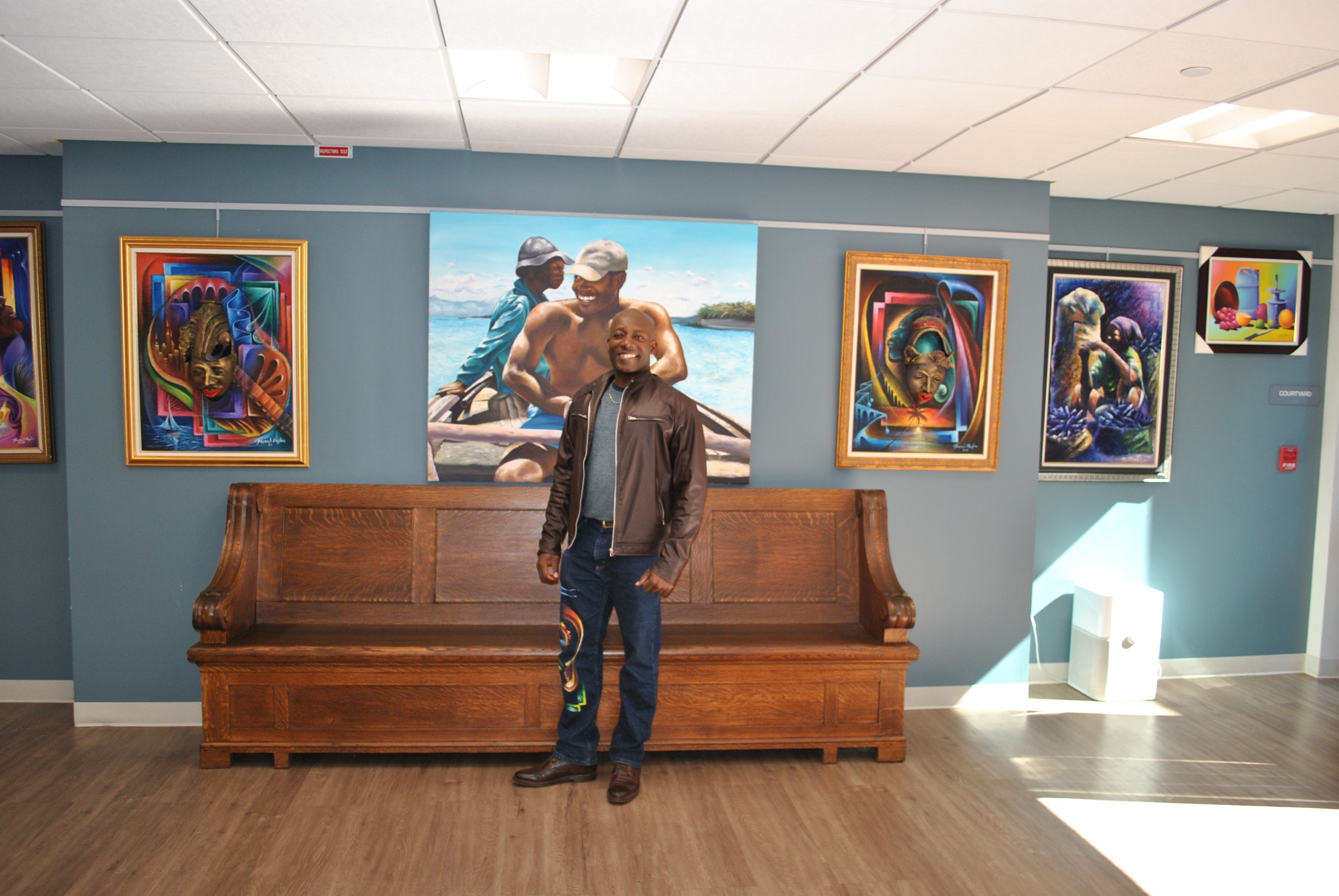 Frenal Mezilas in front of his work