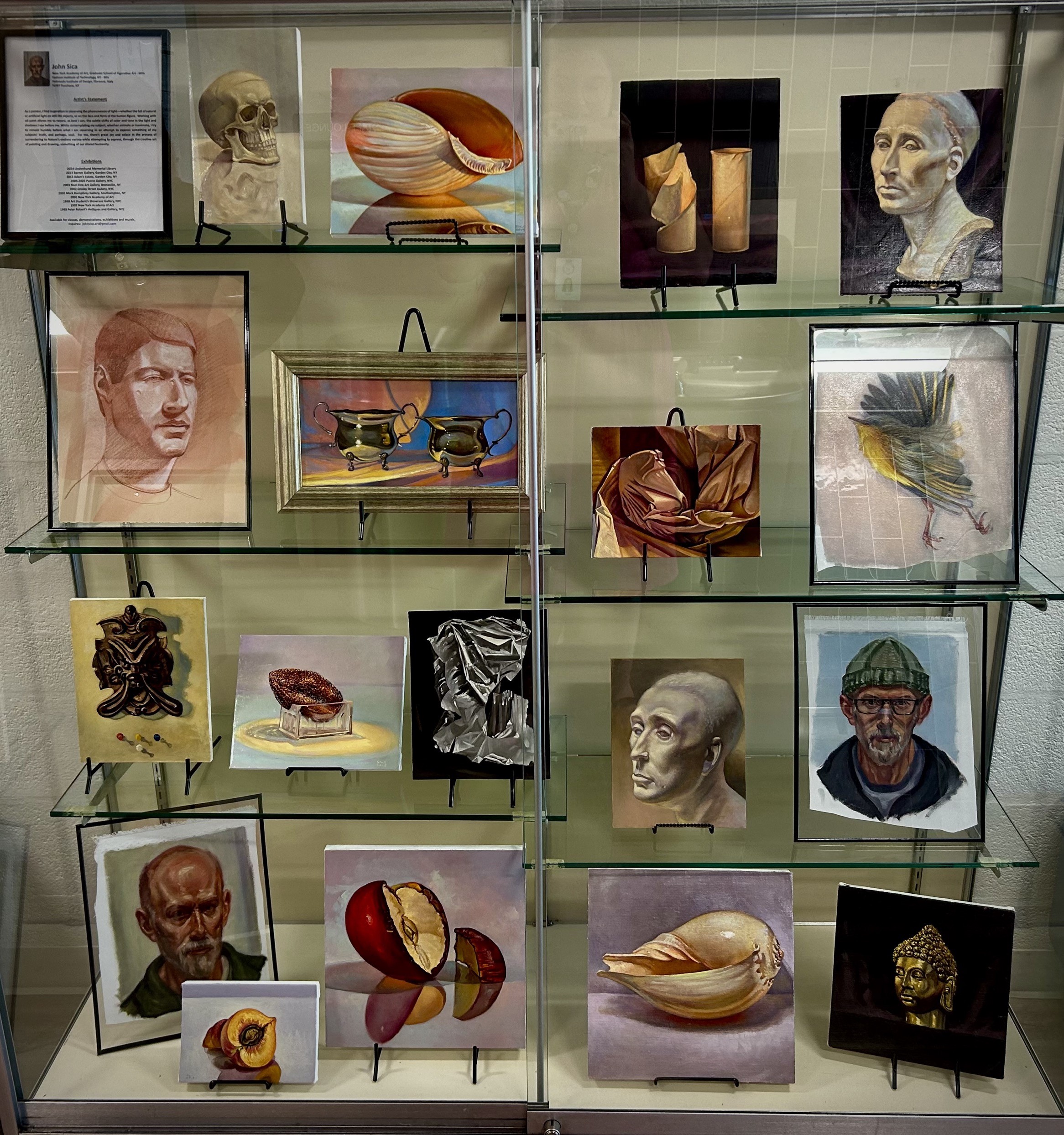 various small paintings in a glass display case