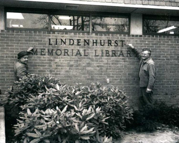 Black and white photo of the Lindenhurst Memorial Library with two men standing in front